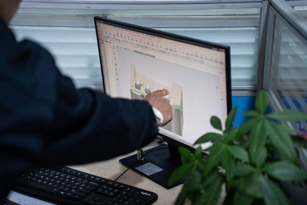 Designer working on CAD model of fiber distribution box – front view