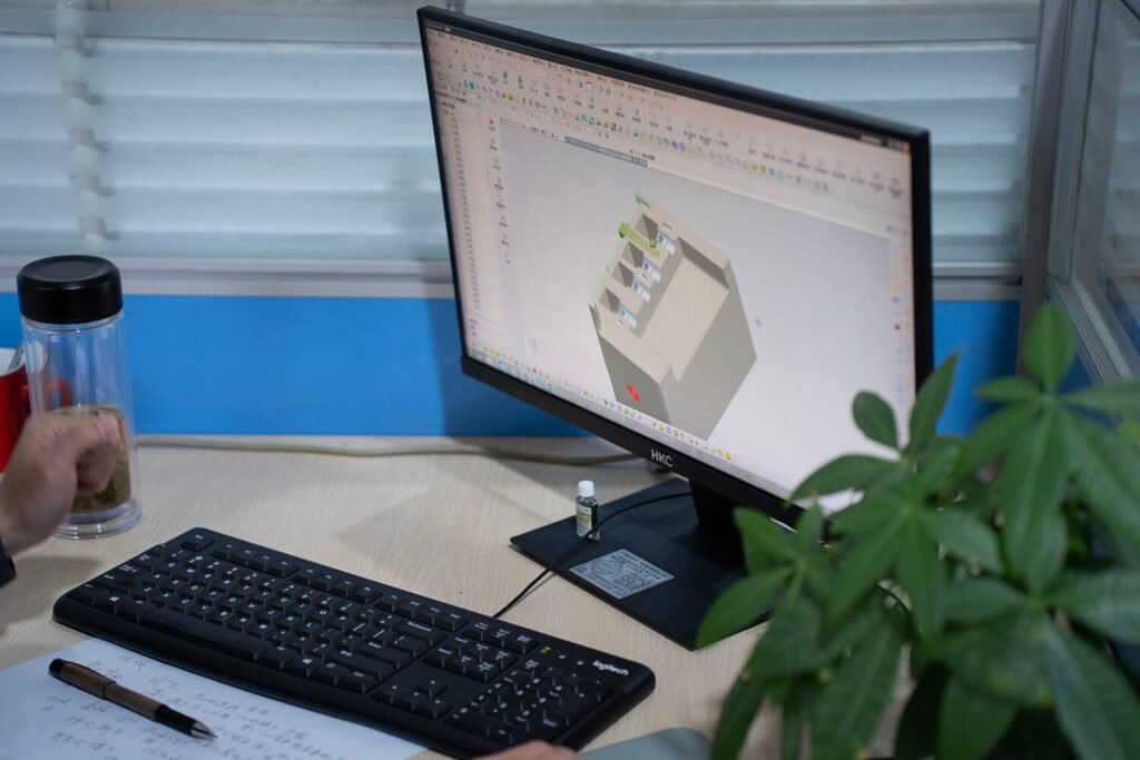 デザイナーがCAD端末ボックスモデルを操作する手のクローズアップ