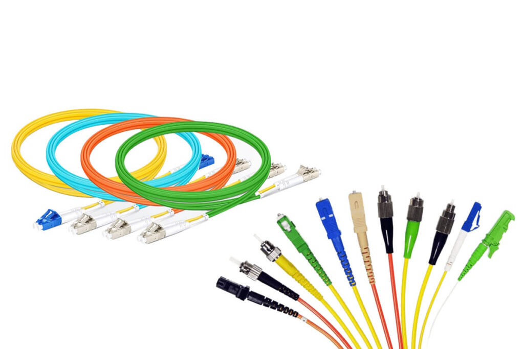 Varios latiguillos de fibra óptica con diferentes colores de conector, incluidos azul UPC y verde APC.