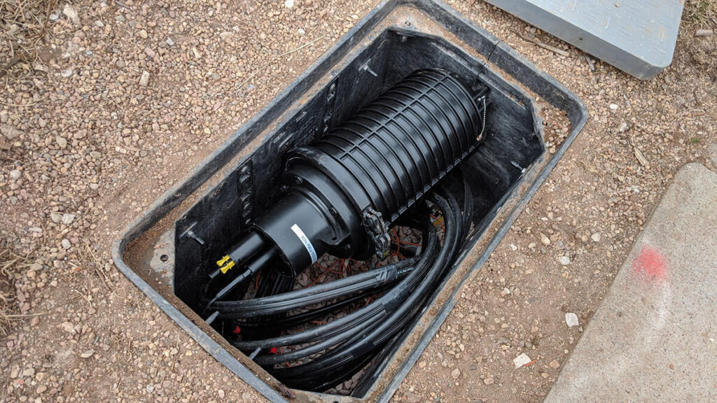 Underground fiber splice closure installation (Image source: https://bikerglen.com/blog/fort-collins-connexion-ftth-part-four/)