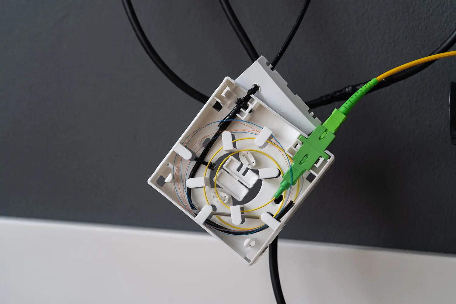 FTTH導入時にターミナルボックス内に光ファイバーケーブルを敷設する技術者